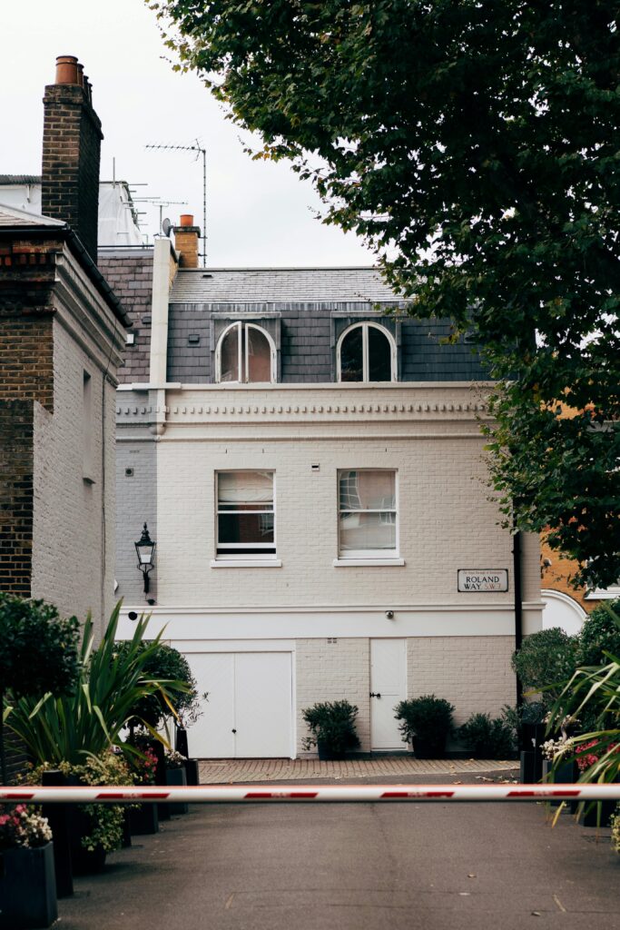 A picturesque townhouse in London framed by lush green trees, highlighting architectural charm.