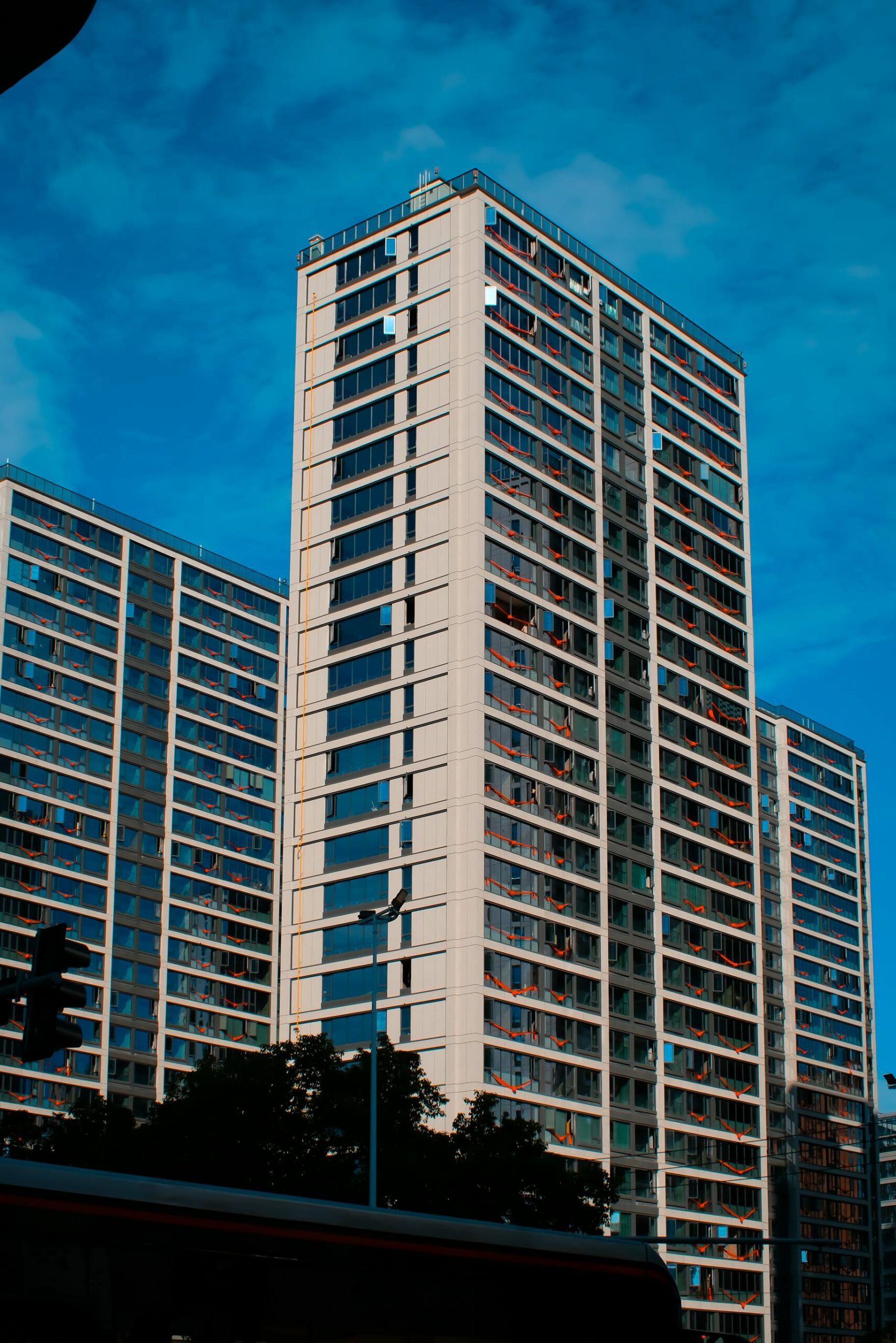 Tall contemporary high-rise apartments with clear blue sky backdrop.