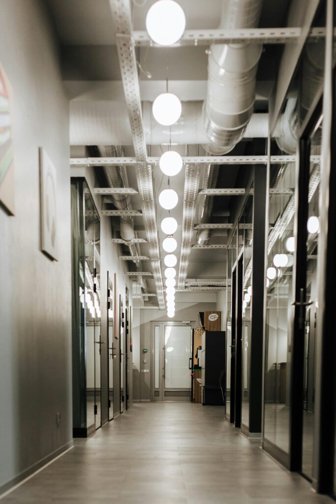 Sleek modern office hallway with bright ceiling lights enhancing the interior design.